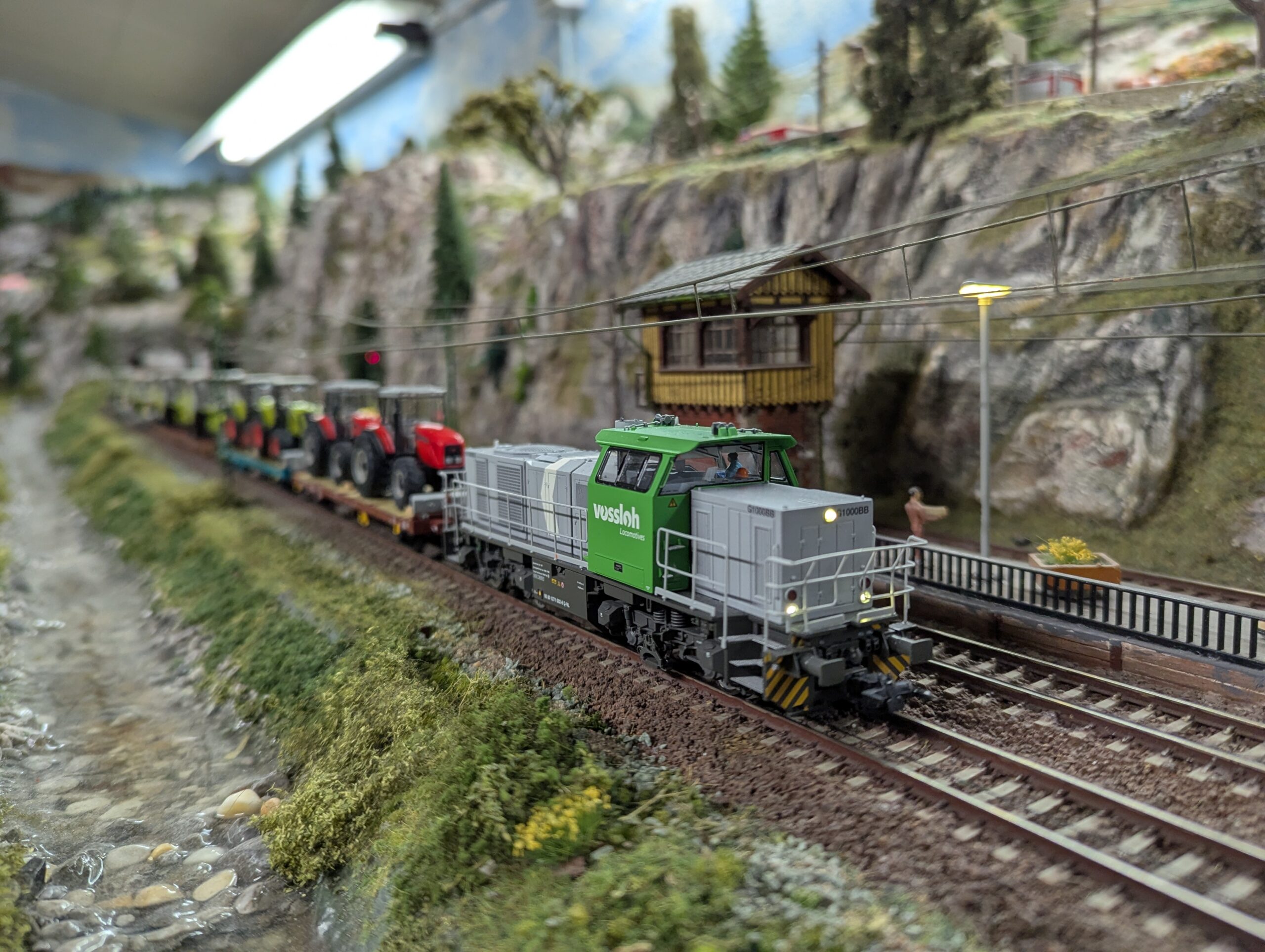 Grüne Diesellok mit Güterzug auf einer Modellbahnanlage