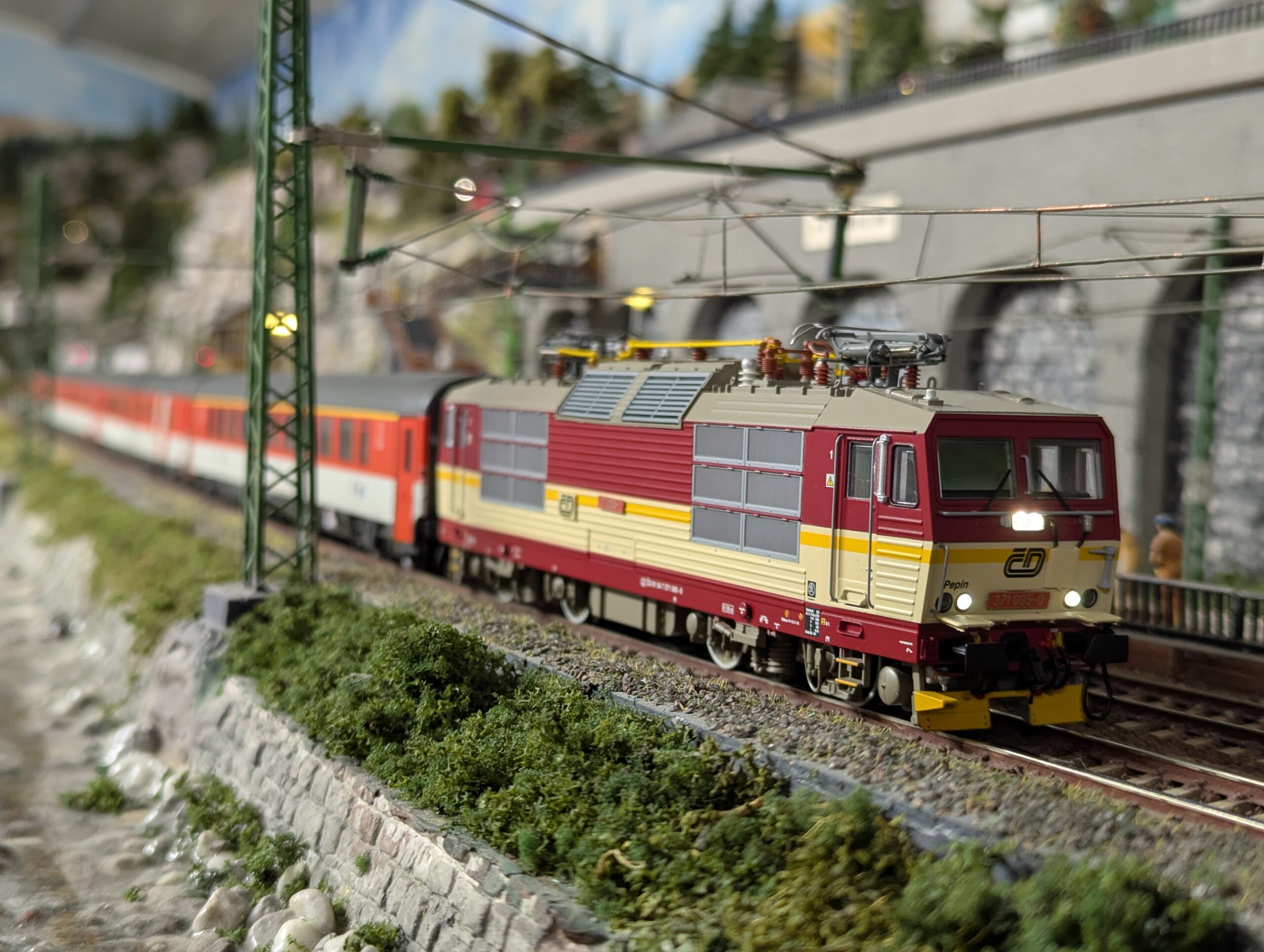 Rot-gelbe Elektrolok mit Personenzug auf einer Modellbahnanlage